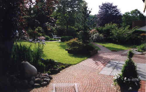 Terrasse in Klinker kombiniert mit Sandstein. Kreise und Halbkreise sind aus Klinker Mosaiksteinen